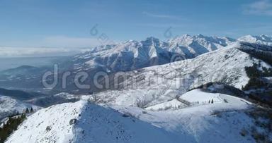 在阳光明媚的日子里，在冬季雪山和滑雪跑道上向前俯视。 揭示山谷。 高山雪山